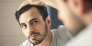 close up of handsome man looking in mirror at home